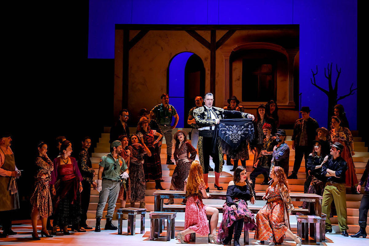 » Carmen «, 2. Akt: Gezim Berisha (Zuniga), Loes Cools (Frasquita), Natalia Ushakova (Carmen), Domenica Radlmaier (Mercédès), dahinter Thomas Weinhappel (Escamillo) sowie Ballett und Chor der Bühne Baden © Bühne Baden/Lalo Jodlbauer