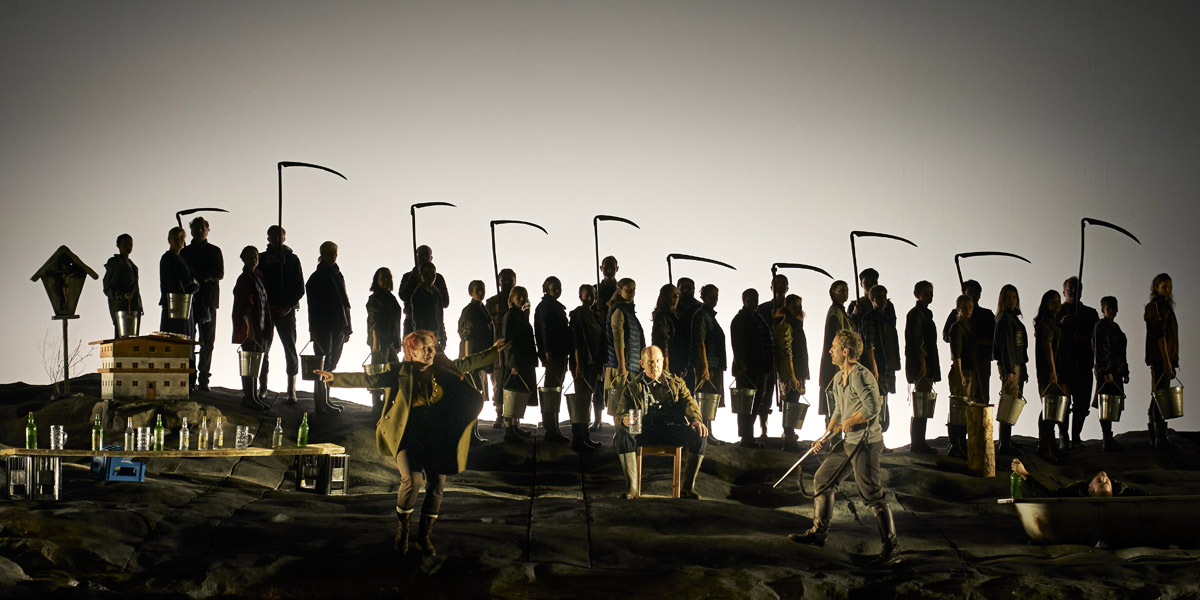 » La Wally «, 1. Akt: Izabela Matula (Wally), Alastair Miles (Stromminger), Jacques Imbrailo (Vincenzo Gellner) und, im Hintergrund, die Mitglieder des Arnold Schoenberg Chors © Theater an der Wien/Herwig Prammer